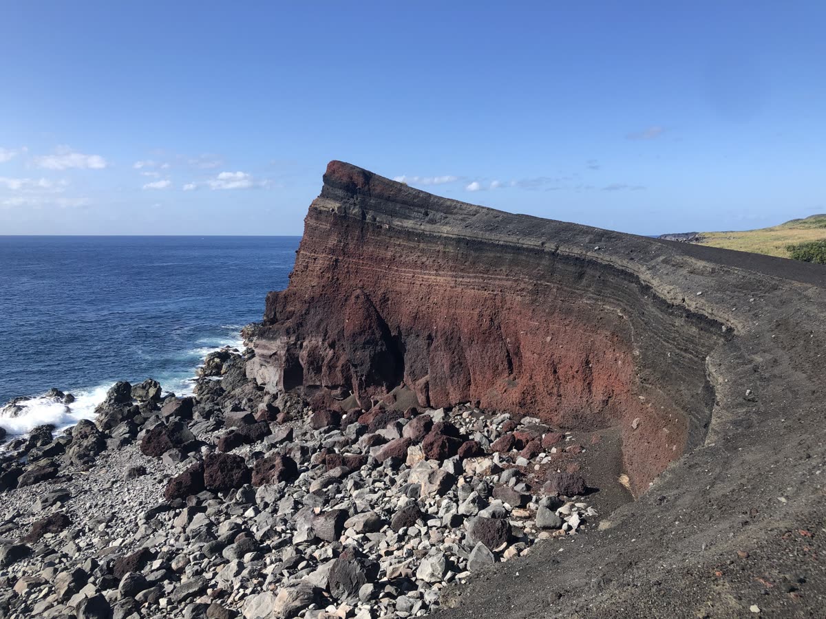 三宅島の海岸に残る赤い火山の崖